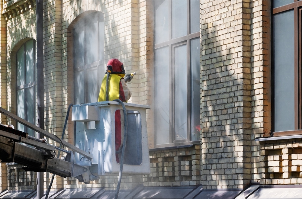 Controle na gevelreiniging in Den Haag gericht op zand, wind, kantoorentrees, plinten en gevelsteen.