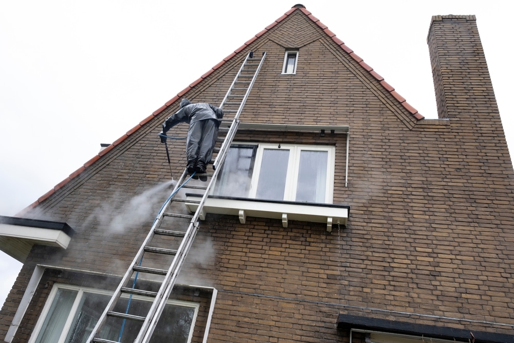 Gevelreiniging van plintzone en entree met vuilranden